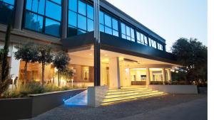 a large glass building with stairs in front of it at Alasia Boutique Hotel in Limassol