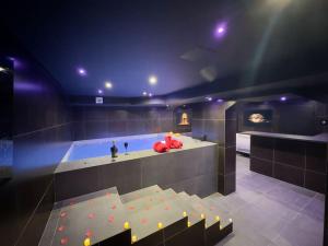 a room with a hot tub with red balls in it at Duplex jacuzzi et table massage in LʼEscarène +1 photo
