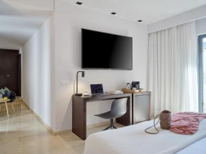 Televízia a/alebo spoločenská miestnosť v ubytovaní Hotel Rey Alfonso X