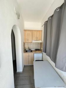 a small kitchen with wooden cabinets and a table at Deep Blue Rooms & Apartments in Mylopotas