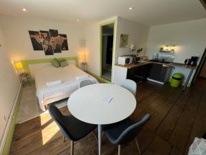 1 dormitorio con 1 cama blanca, mesa y sillas en La Maison Fiets Meuse & Vélo, en Damblain 12 fotos más