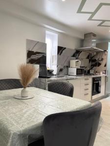 a kitchen with a table with chairs and a laptop at Stanton - 1 Stylish Bedroom in Dagenham