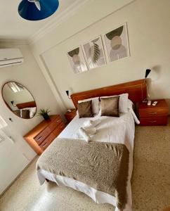 a bedroom with a large bed and a mirror at Cozy apartment next to center in Seville