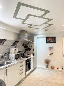 a kitchen with a ceiling with a microwave and a sink at Stanton - 1 Stylish Bedroom in Dagenham +2 photos