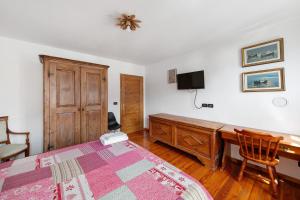 Schlafzimmer mit einem Schreibtisch, einem Bett und einem Schreibtisch in der Unterkunft Appartamento San Lorenzo 1 a Vinigo in Vinigo