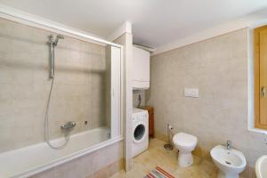 ein Bad mit einer Dusche, einem WC und einer Waschmaschine in der Unterkunft Appartamento San Lorenzo 1 a Vinigo in Vinigo + 13 Fotos