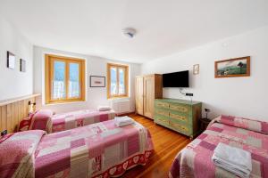 ein Schlafzimmer mit zwei Betten und einem Fernseher darin in der Unterkunft Appartamento San Lorenzo 1 a Vinigo in Vinigo