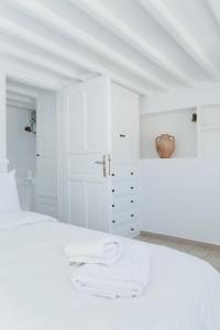 a white bedroom with a white bed and white cabinets at Manto Sunset Loft in Mýkonos City