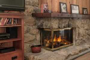 a stone fireplace with a fire in it at Beaver Village Unit #0232R in Winter Park