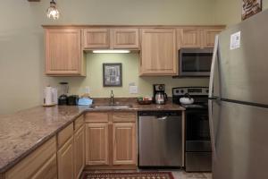 a kitchen with wooden cabinets and a stainless steel refrigerator at Beaver Village Unit #0232R in Winter Park