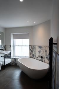 a large bath tub in a bathroom with a window at The Cae Mor Hotel in Llandudno +197 photos