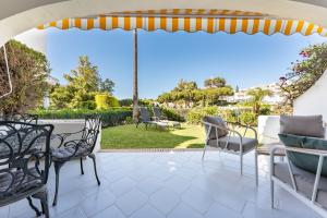 un patio con sillas y una sombrilla en Holiday Home 'Miraflores Rancho', en La Cala de Mijas