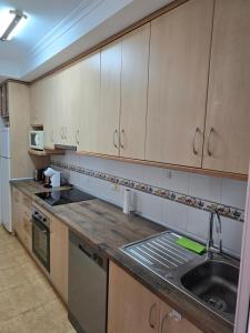 a kitchen with wooden cabinets and a sink at Casa Aleks Lo Pagan in San Pedro del Pinatar +2 photos