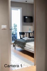 una camera da letto con un letto, un tavolo e una finestra di Berht - Appartamenti al centro di Catania a Catania Altre 31 foto