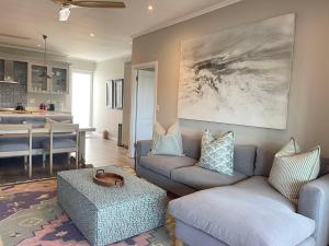 a living room with two couches and a table at Beachy Head Hideaway 11 Seaside Luxury Stay in Plettenberg Bay