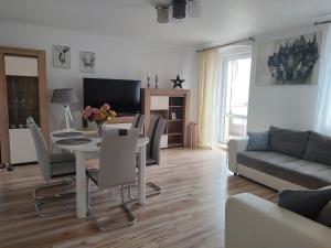 a living room with a table and chairs and a couch at Sea&Wine Apartamenty Darłówko in Darlowko