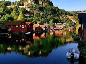 a boat in a body of water with houses at Svindland Camping in Kvinesdal