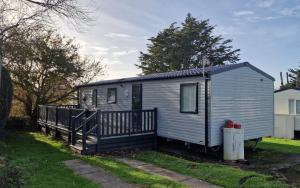 a tiny house in a yard with a trash can at JJ's Holiday Space in Selsey