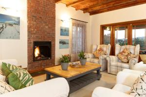 a living room with couches and a fireplace at The Loop Farmhouse Mooi River in Mooirivier
