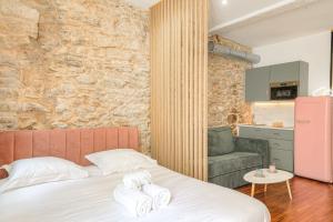 a bedroom with a bed with two towels on it at Design et Pop avec balnéo in Lyon