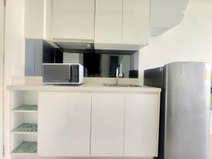 a kitchen with white cabinets and a refrigerator at Unique studio in town in Pattaya Central