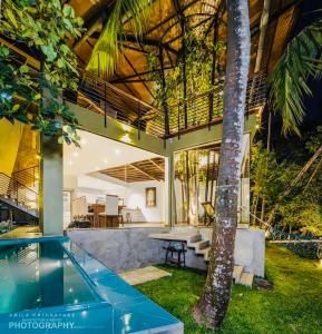 a house with a swimming pool and a tree at Villa 47 Colombo in Pannipitiya