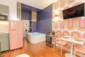 a kitchen with a pink refrigerator and a table at Design et Pop avec balnéo in Lyon