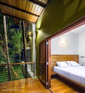 a bedroom with a bed and a balcony at Villa 47 Colombo in Pannipitiya
