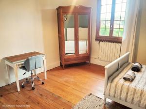 a bedroom with a bed and a desk and a table at Maison pour 2 personnes en cœur de bourg in LʼIsle-en-Dodon