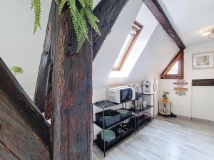 ein Dachzimmer mit einer großen Holzwand und einer Mikrowelle in der Unterkunft LE MARCARON - Hypercentre Obernai - Confort - Lumineux in Obernai