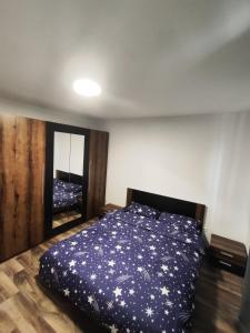 a bedroom with a bed with a blue comforter at Apartament Luna in Jurilovca