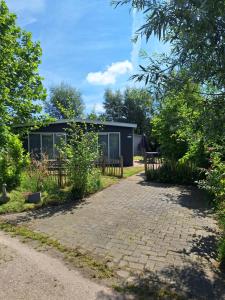 MolenschotThe Bright Side Brabant的一座带围栏和砖砌车道的房子