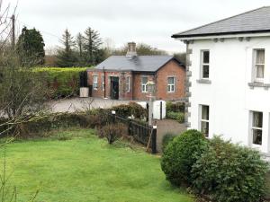 a house with a grass yard in front of it at Railway Cottage in Cork
