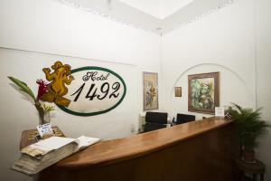 a reception desk with a sign on the wall at Hotel 1492 in San José