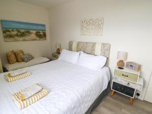 Un dormitorio con una cama con una colcha blanca. en Sunset Sands, en Conwy