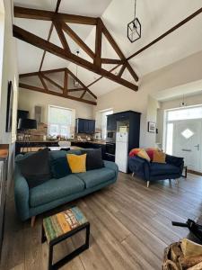 a living room with a blue couch and a kitchen at Railway Cottage in Cork