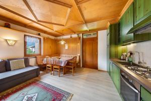 eine Küche und ein Wohnzimmer mit einem Tisch und einer Couch in der Unterkunft Appartamento Michaela a Vinigo in Vinigo