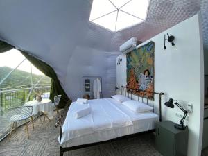 una camera da letto con un letto e un balcone con un tavolo di Mandarina - Cosmo Dome a Ch'aisubani