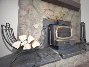 a stone fireplace with a tv on top of it at Meadowridge Court 19 Unit 1 in Fraser