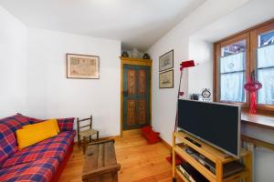 a living room with a couch and a flat screen tv at Casa San Giovanni 1 a Vinigo in Vinigo