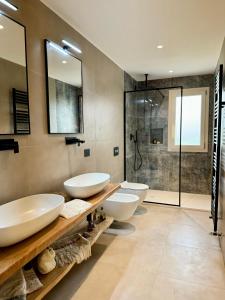 a bathroom with two sinks and a shower at Villa Berenike in San Teodoro +49 photos