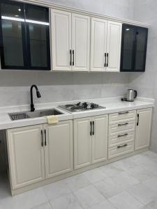 a kitchen with white cabinets and a sink at شقق مفروشه للايجار اليومي بالطائف in Al Ḩawīyah