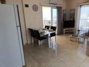 a living room with a table and chairs and a television at Adalena Court in Protaras