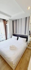 a large white bed with two towels on it at Cosy SeaView, High Floor, free Netflix in Bangsaen +14 photos