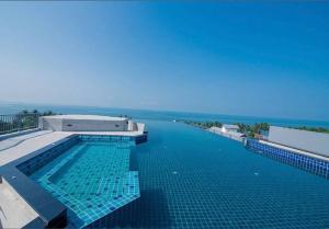 a swimming pool with a view of the ocean at Cosy SeaView, High Floor, free Netflix in Bangsaen