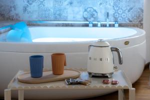 a coffee maker on a tray next to a bath tub at Vsuite livingchic in Cagliari +23 photos