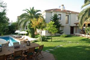 a backyard with a table and chairs and a house at Parla Viens Suites in Gebze