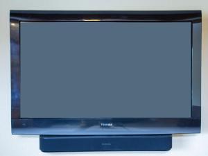 een televisie met een blauw scherm staat op een tafel bij Miles Behind Log Cabin in Fraser