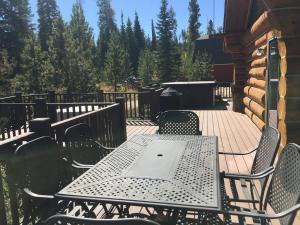een tafel en stoelen op een terras met een grill bij Miles Behind Log Cabin in Fraser +62 foto's