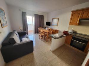 a living room with a couch and a kitchen with a table at Las Floritas 2 in Arona